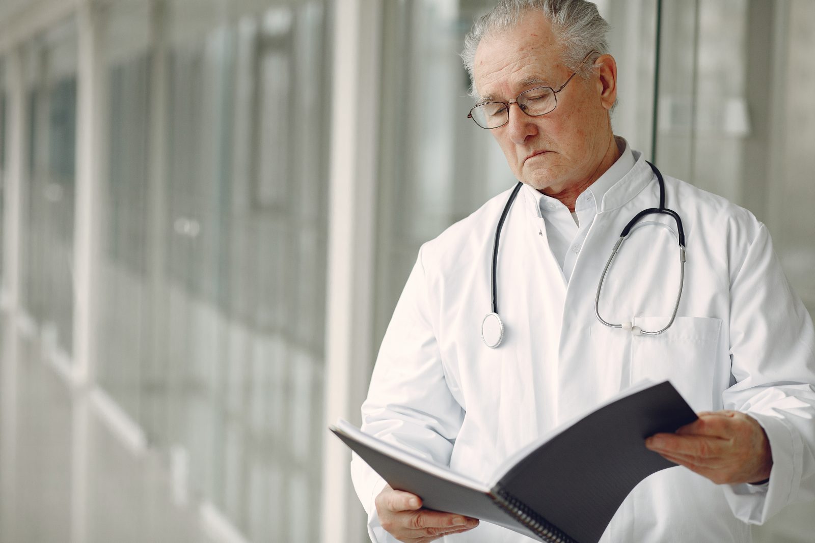 Contemplative doctor in uniform reading clinical records