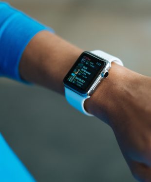 Person wearing white silicone strap black smartwatch