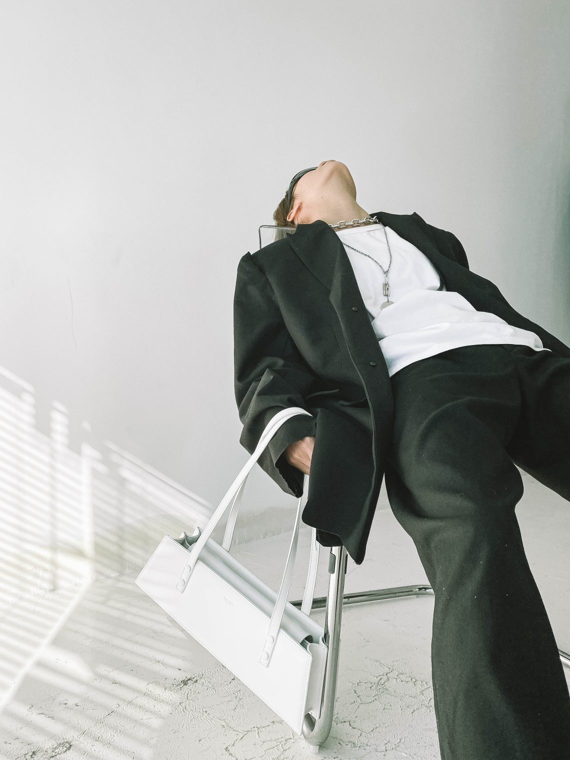 Stylish woman wearing suit lying on chair